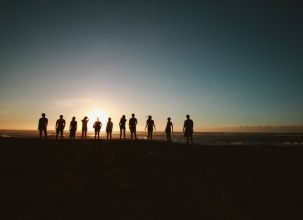 picture of people standing on the horizon in front of sunrise