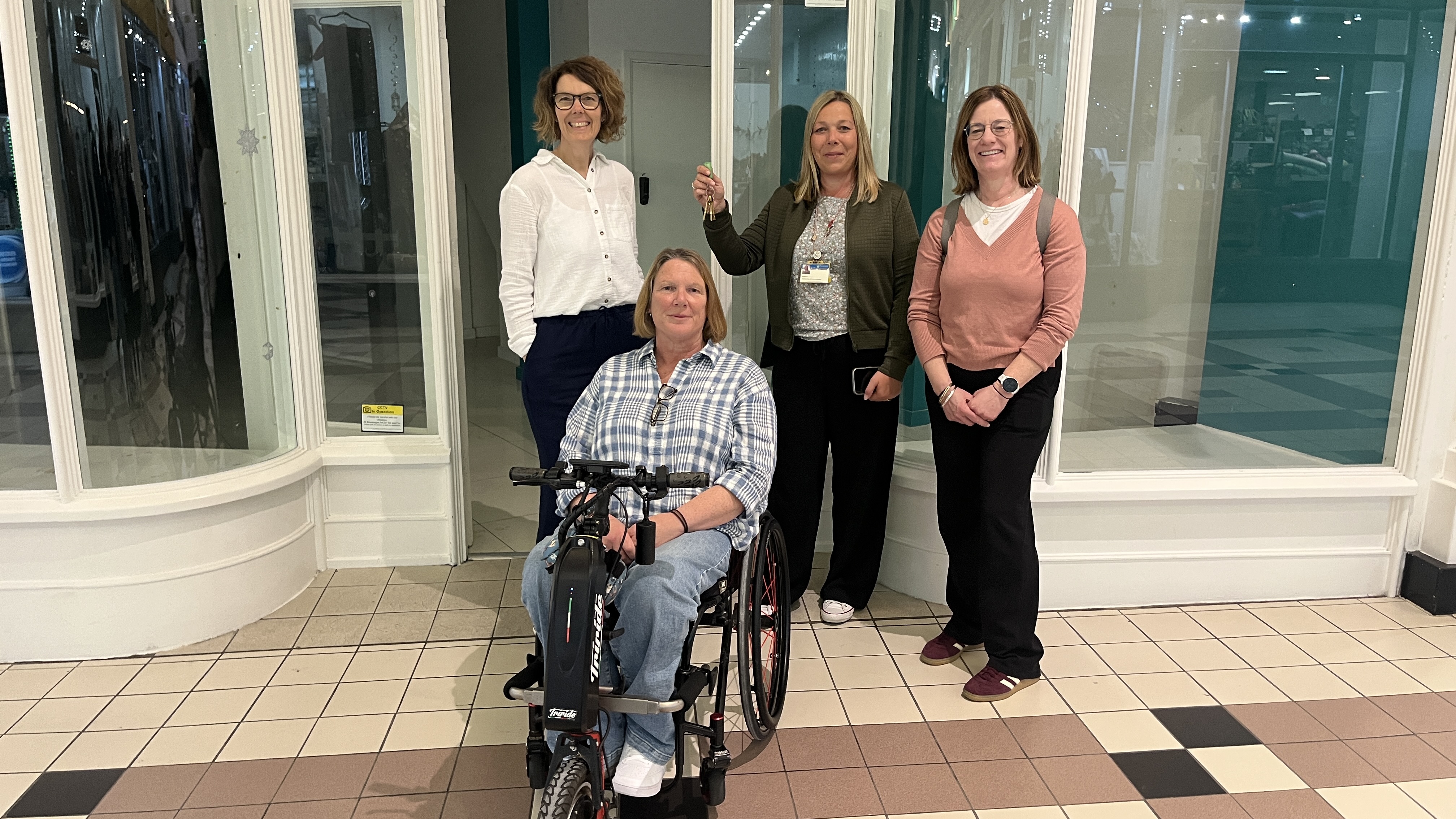 HIVE staff holding the keys outside the Disability Hub