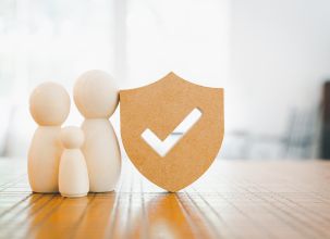 Picture of two large and one small wooden people next to a shield with a tick on it